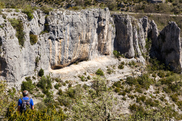 Falaise d'escalade avec personne observant les préparatifs d'une cordée. Gorge d'Oppedette, Parc naturel régional du Luberon - obrazy, fototapety, plakaty