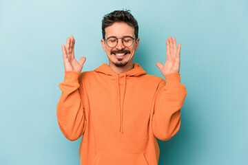 Naklejka premium Young caucasian man isolated on blue background joyful laughing a lot. Happiness concept.