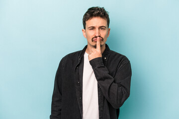 Young caucasian man isolated on blue background thinking and looking up, being reflective, contemplating, having a fantasy.