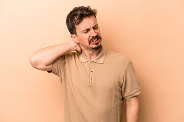 Young caucasian man isolated on beige background tired and very sleepy keeping hand on head.