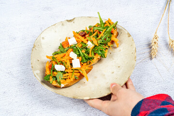 Delicious sandwich with natural organic bread, cheese, carrots, olives, herbs and spices. Selective focus.