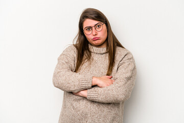 Young caucasian overweight woman isolated on white background suspicious, uncertain, examining you.