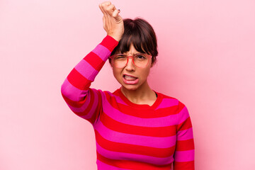 Young hispanic woman isolated on pink background forgetting something, slapping forehead with palm and closing eyes.