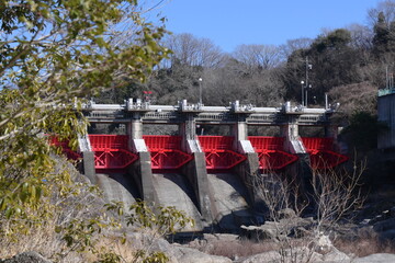 青空と木々と赤いダム