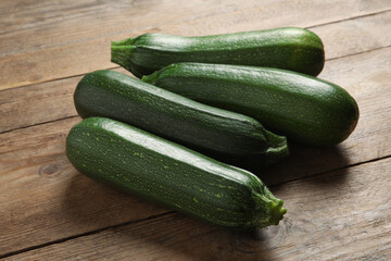 Many raw ripe zucchinis on wooden table