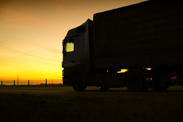 A beautiful truck with a trailer against the backdrop of an evening sunset before night. The...