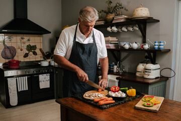 Caucasian male cooking in kitchen chopping vegies