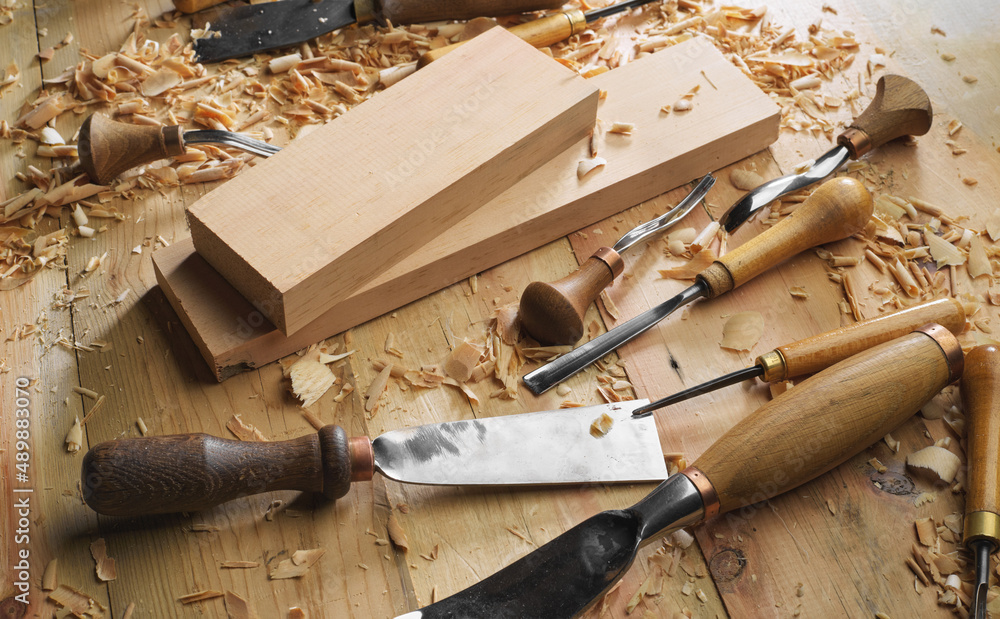 Wall mural Woodworker. Timber, wood processing. Joinery work. Wood carving with work tools close up. Hand of carver carving wood. Craftsman carving with a gouge