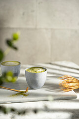 Organic green matcha tea with milk. Matcha powder and tea drink in a bowl. Chasen bamboo whisk for...