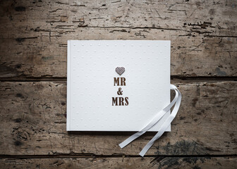 Mr Mrs bride and groom guestbook with beautiful Diamond crystal love heart on solid oak retro vintage wooden table. - obrazy, fototapety, plakaty
