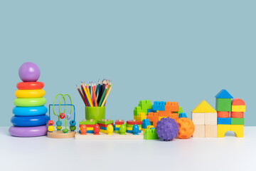 A colorful set of educational toys for preschool children. Wooden and plastic toys on a blue background. Copy space