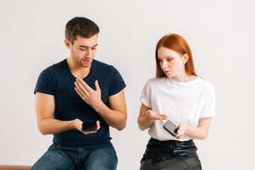 Studio portrait of sad young woman angry to boyfriend using smartphone all the time without paying...