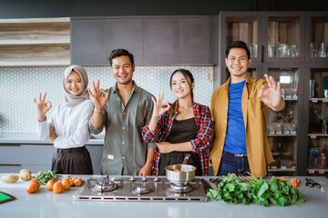 friends preparing to cook in the kitchen together showing thumb up