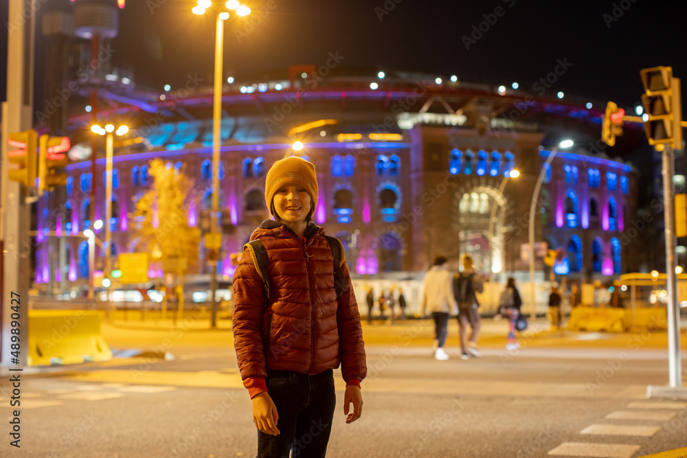 Sticker Cute little child, standing in front of the Arena building at night, tourists admiring Barcelona city, family travel with kids