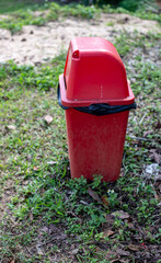 Fototapeta premium Red bin in the park and blurred background.
