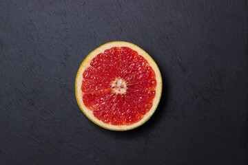 Half of a grapefruit on a black background. Ripe citrus fruit.