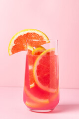 Pink cocktail with grapefruit on a pink background. Sweet fruit cocktail. delicious drink