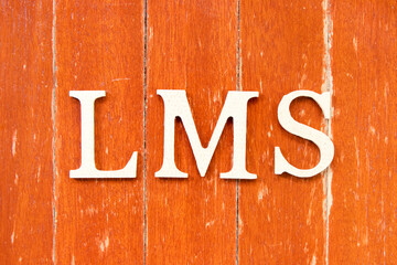 Alphabet letter in word LMS (Abbreviation of Learning management system) on old red color wood plate background