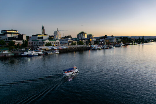 a tourism boat sailing across the Calle-Calle river in Valdivia, southern Chile during sunset