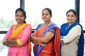 Confidently standing Indian woman at office with crossed arms looking at camera - concept of...