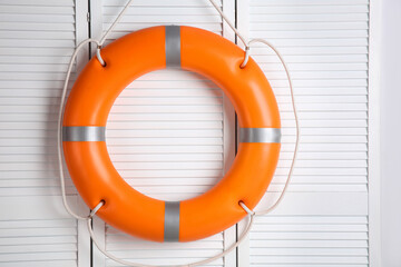 Orange lifebuoy on white wooden background. Rescue equipment