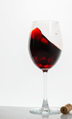 Crystal glass with red wine on white background. moving liquid, red wine pouring into wine glass.