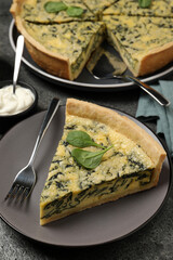 Piece of delicious spinach pie served on grey table