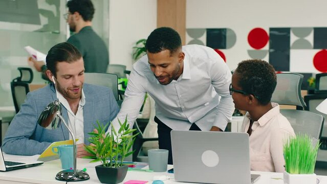 A Very Good Looking Black Man Is Talking To His Two Co Workers And Showing Some Stuff On A Paper On The Desk, They Are In A Very Nicely Decorated Office. Arri Alexa Mini.