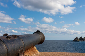 Fototapeta na wymiar Old cannon at fortress aiming at sea