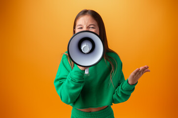 Teen girl making announcement with megaphone against orange background