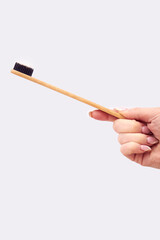 Close Up Studio Shot Of Woman Holding Sustainable Wooden Toothbrush