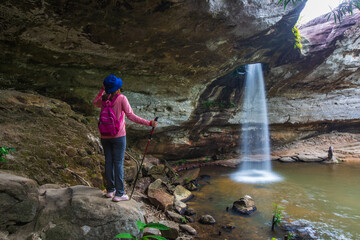 Obraz premium Young woman hiking in Sang Chan Waterfall, Beautiful waterfall in Pha Tam national Park, Ubon Ratchathani province, ThaiLand.