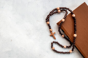 Old Bible book and rosary beads with cross. Christian religion concept