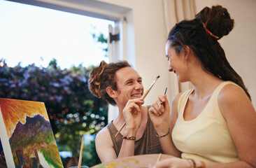 Making memories theyll always cherish. A young couple painting together and having fun.