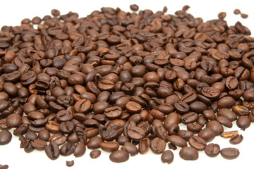 stacked roasted coffee beans on a white background