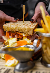 wooman hand cooking big sandwich with meat and vegetables on kitchen