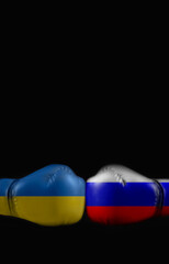 Flags of Russia and Ukraine on boxing gloves on a black background. Political conflict between...