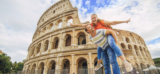 Fototapeta na wymiar Happy couple - woman and man tourist have fun on vacation at Rome Colosseum