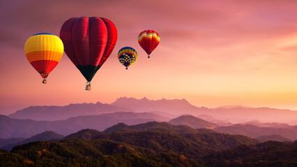 Hot air balloon above high mountain at sunrise, sunset. View of mountain with hot air balloons on...