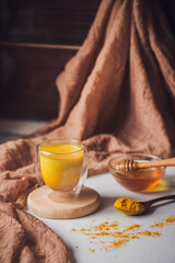 Turmeric latte, Cooking Golden Milk On Kitchen. Hot healthy drink. Milk, turmeric, honey