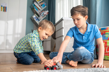 Two kids playing with their toy vehicles
