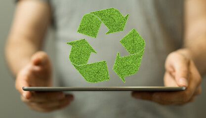 hand holding green recycle symbol