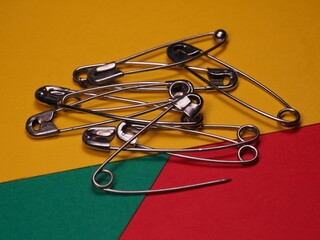 Fototapeta premium Safety pins on a colored background. Safety pin for help close or temporarily mend damaged clothes.