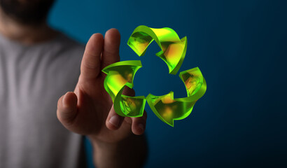 hand holding green recycle symbol
