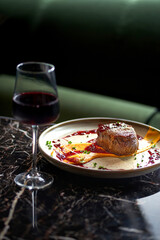 Grilled fillet steaks on a ceramic plate and glass of red wine