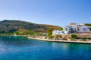 Fototapeta premium Beautiful summer day, sunshine in typical town of Greek island. Whitewashed houses on hills. Mediterranean vacations. Milos, Cyclades, Greece.