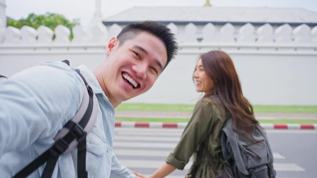 Asian couple backpacker use mobile phone selfie, take picture in city. 