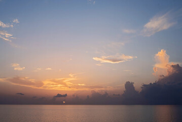 Naklejka na ściany i meble Sunrise on a flat calm morning at sea