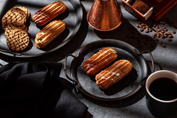 Coffee eclairs on a vintage plate, coffee, coffee grinder.