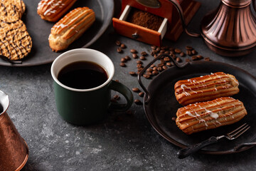 Coffee eclairs on a vintage plate, coffee, coffee grinder.